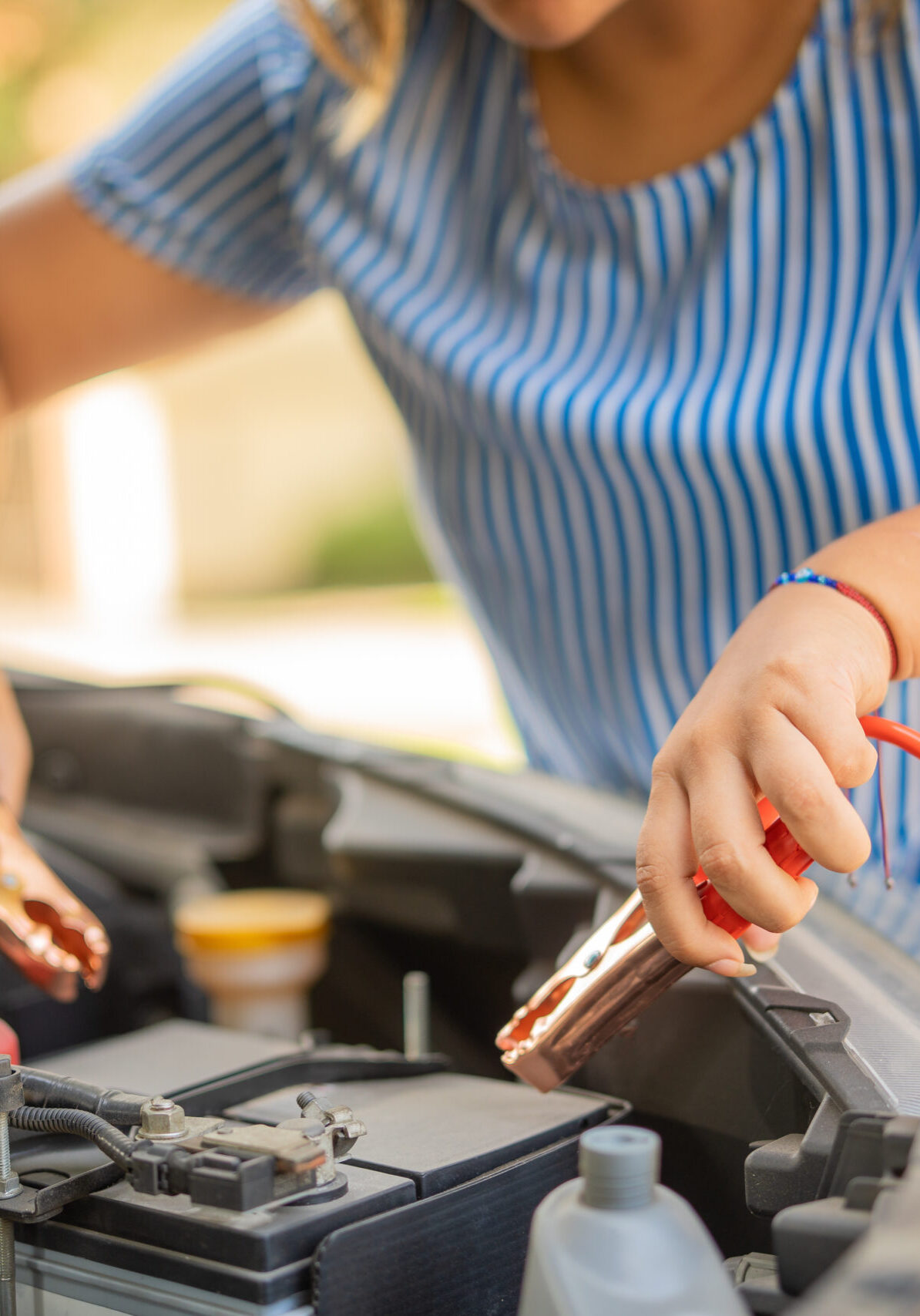 Woman fixing her vehicle while waiting for the tow truck to arrive